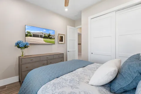 a bedroom with a bed and a potted plant on dresser