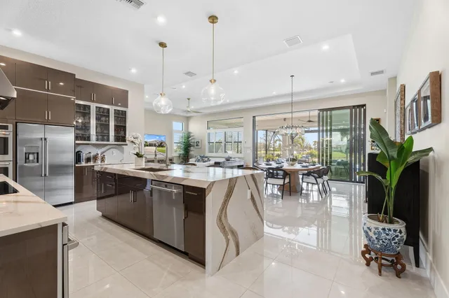 a kitchen with a stove a counter space a sink and living room view