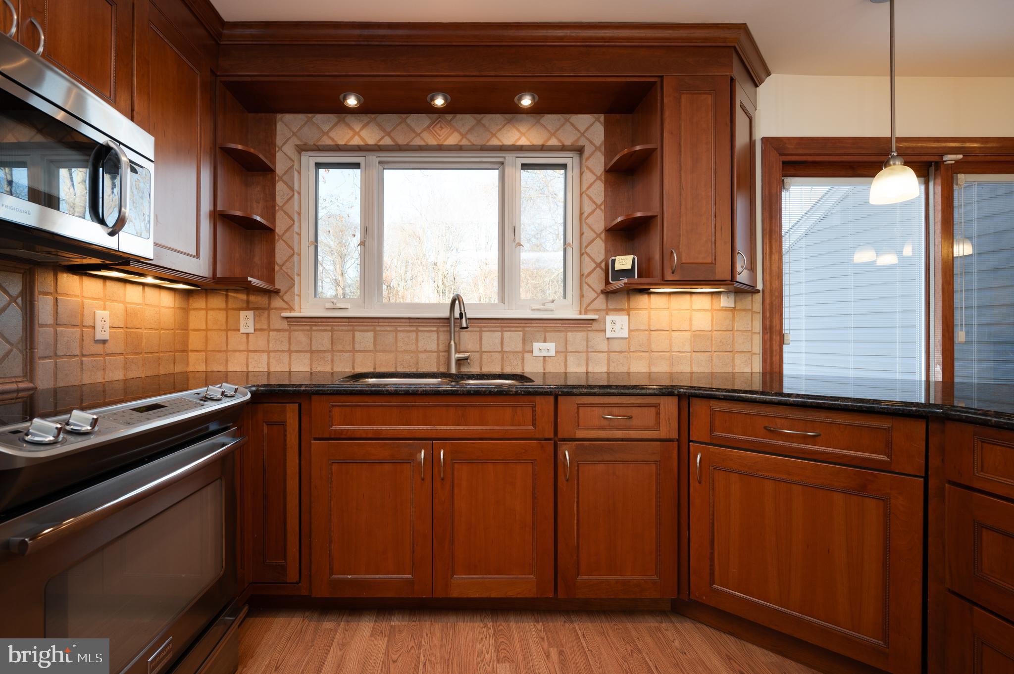 128 Birch Knoll Road Wilmington, DE 19810 - Photo 15 of 51 a kitchen with kitchen island granite countertop wooden cabinets and a stove