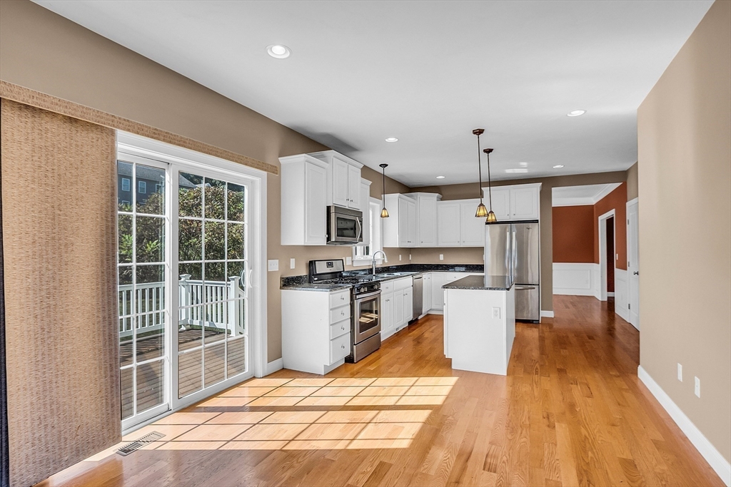 17 Runaway Brook Road Lancaster, MA 01523 - Photo 14 of 42 a kitchen with stainless steel appliances kitchen island granite countertop a refrigerator oven a sink dishwasher and white cabinets with wooden floor