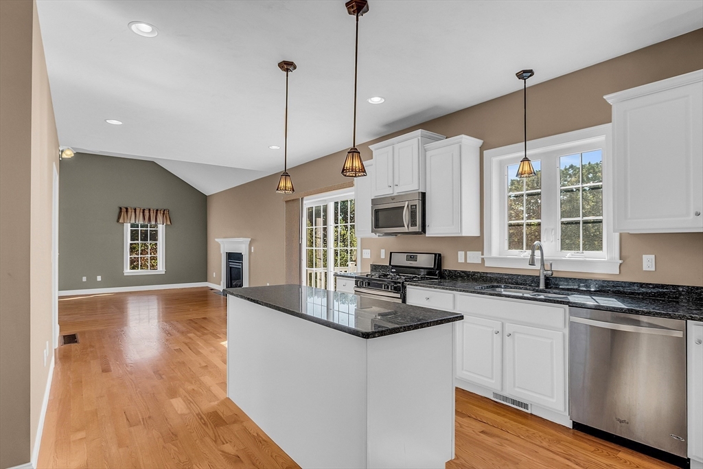 17 Runaway Brook Road Lancaster, MA 01523 - Photo 16 of 42 a kitchen with stainless steel appliances granite countertop a stove a sink and white cabinets with wooden floor