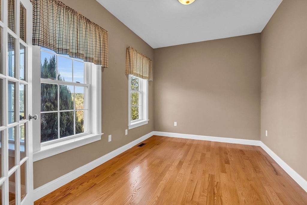17 Runaway Brook Road Lancaster, MA 01523 - Photo 5 of 42 a view of an empty room with a window and wooden floor