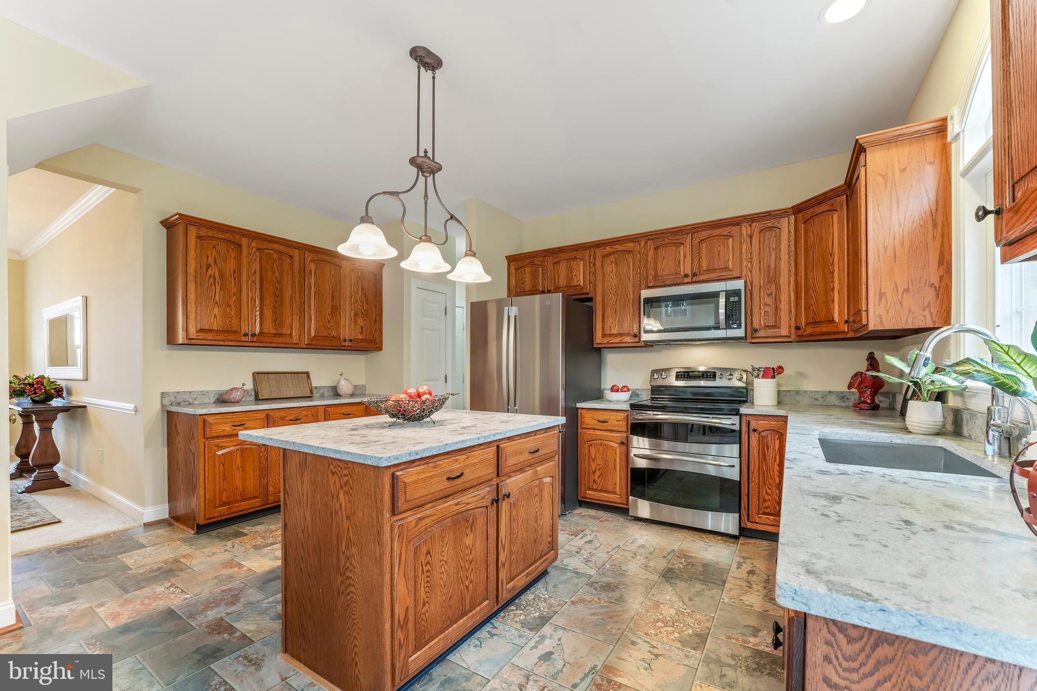 730 Garden Drive Kennett Square, PA 19348 - Photo 19 of 39 a kitchen with stainless steel appliances granite countertop a stove top oven a sink dishwasher a dining table and chairs with wooden floor