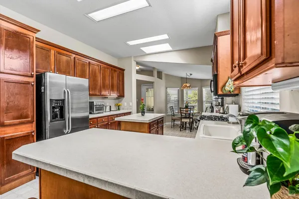 a kitchen with stainless steel appliances granite countertop a refrigerator a sink a stove and cabinets