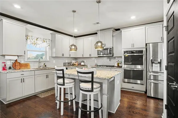 a kitchen with stainless steel appliances a stove a sink refrigerator and a cabinets