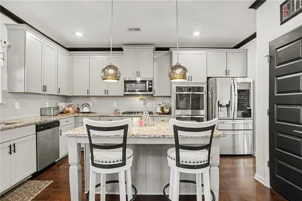 a kitchen with stainless steel appliances granite countertop a stove a sink and a refrigerator