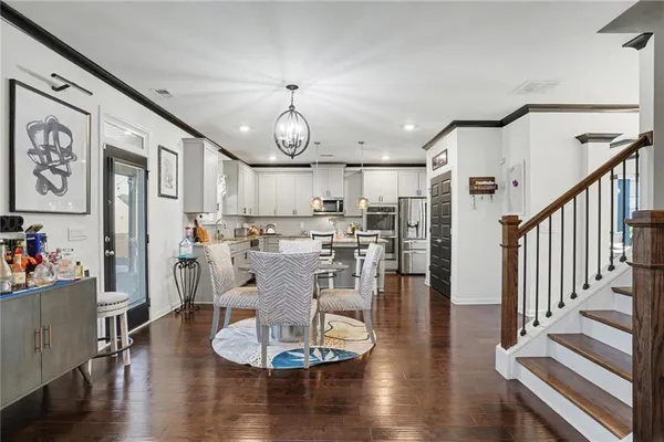 a living room with lots of wooden furniture and kitchen view