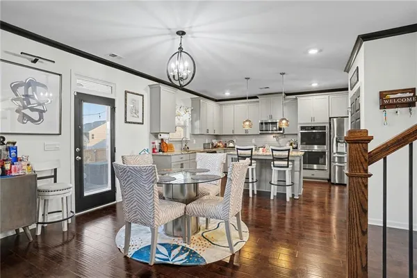 a dining room with wooden floor a glass table and chairs
