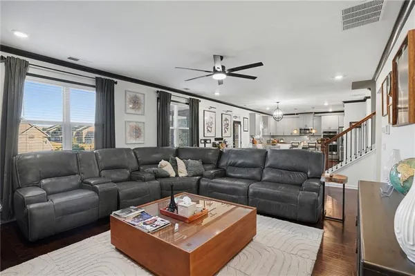 a living room with furniture a ceiling fan and a rug