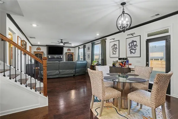 a view of a dining room with furniture a chandelier and wooden floor