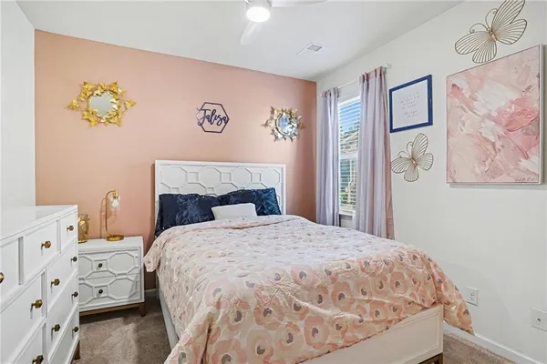 a bedroom with a bed and painting on the wall