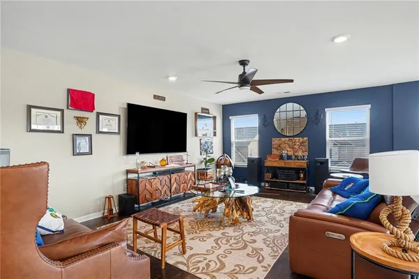 a living room with furniture a flat screen tv and a large window