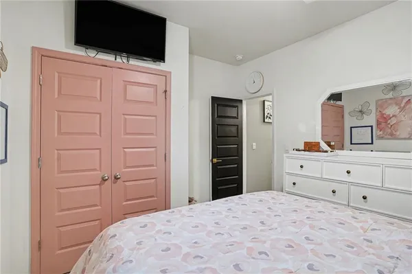 a bedroom with a bed and a flat screen tv in it