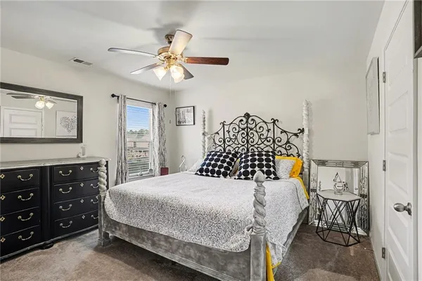 a bedroom with a bed a chandelier and a dresser