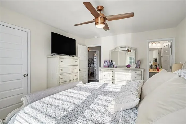 a bed room with a bed a television and dresser