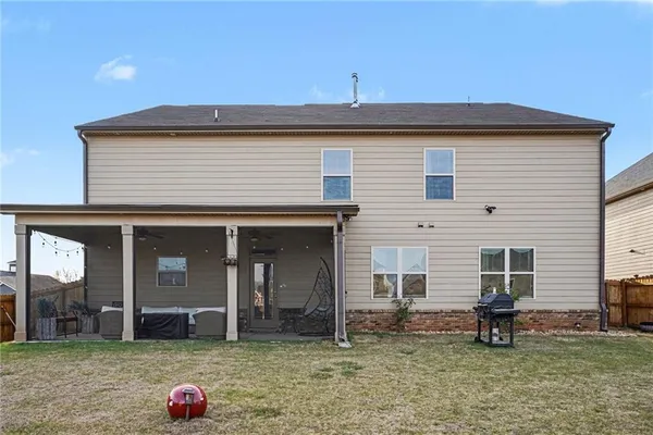 a backyard of a house with yard table and chairs