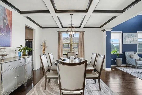 a dining room with furniture a chandelier and wooden floor