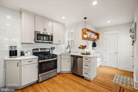 a kitchen with stainless steel appliances a stove sink microwave and cabinets