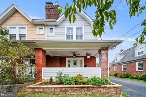 a view of a white house with large windows and a small yard
