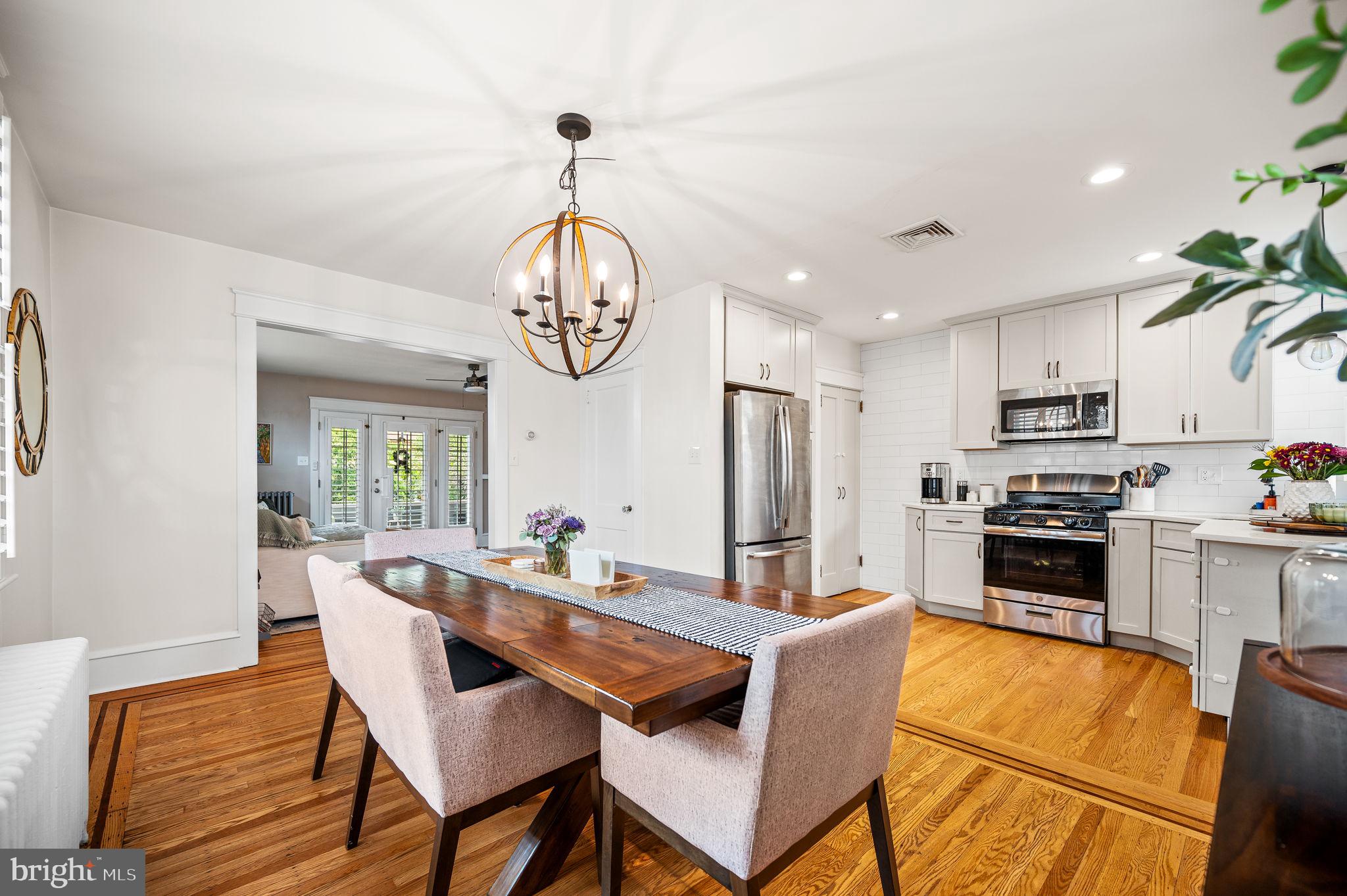 168 Upland Road Havertown, PA 19083 - Photo 7 of 32 a dining room with wooden floor a chandelier a wooden table and chairs