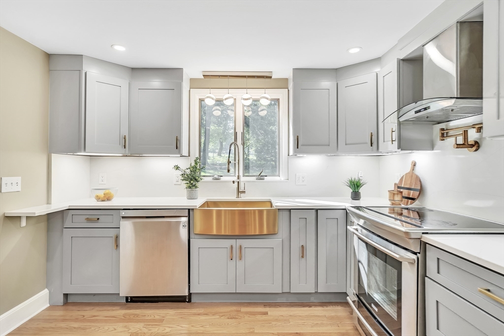38 Maple Street Lexington, MA 02420 - Photo 20 of 40 a kitchen with kitchen island granite countertop a sink cabinets and stainless steel appliances