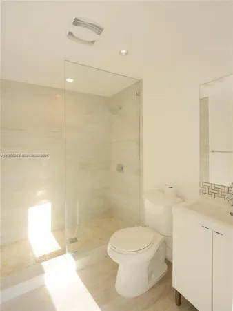 a bathroom with a toilet a sink and shower