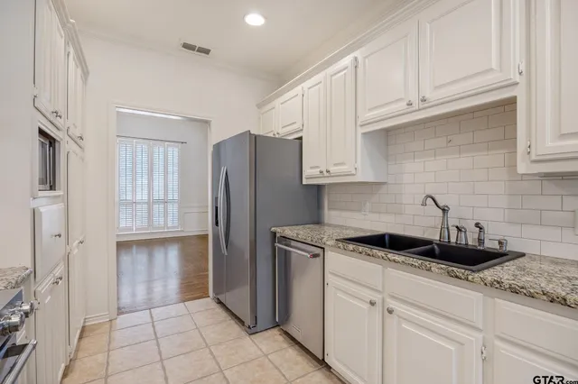 a kitchen with white cabinets and a sink