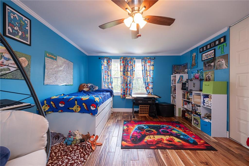 1072 Renton Road Pittsburgh, PA 15239 - Photo 19 of 42 a bedroom with a bed and a bookshelf with wooden floor