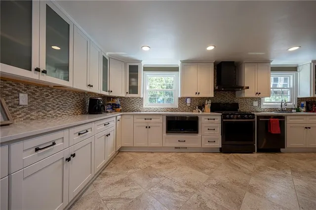 a kitchen with granite countertop a stove sink and cabinets