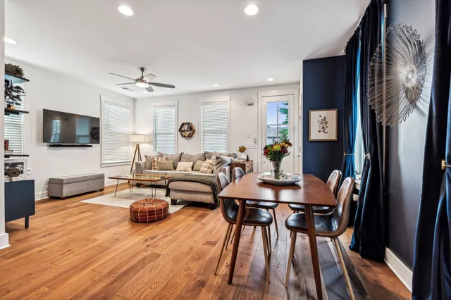 a living room with furniture a flat screen tv and kitchen view
