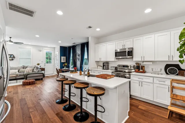 a kitchen with sink a stove and chairs
