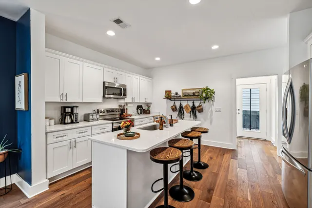 a kitchen that has a sink a stove and chairs
