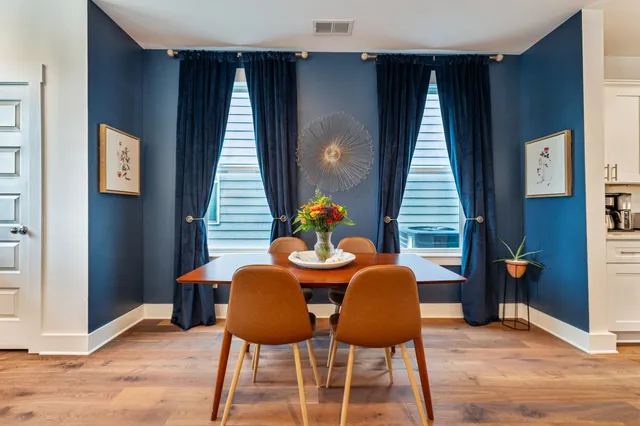 a dining room with furniture and wooden floor
