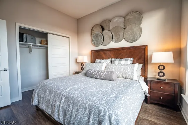 a bedroom with a bed and a night stand next to a window