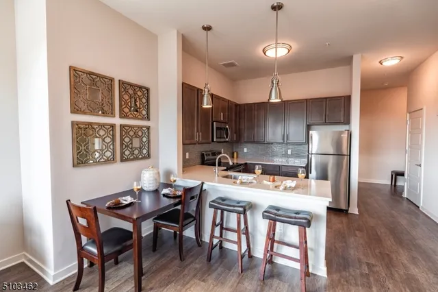 a kitchen with a dining table chairs and refrigerator