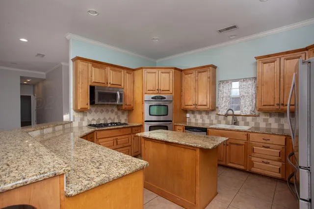 a kitchen with stainless steel appliances granite countertop a refrigerator sink and cabinets