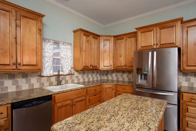 a kitchen with stainless steel appliances wooden cabinets and a stove top oven