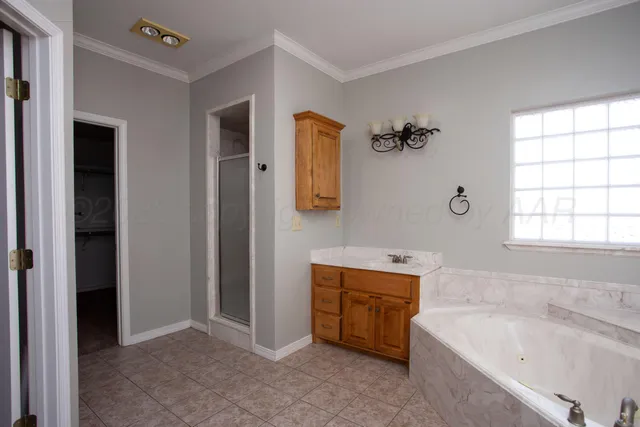 an empty room with a chandelier fan and windows