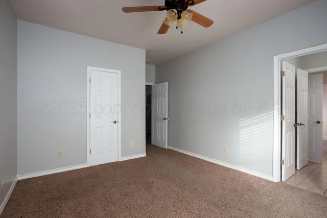 an empty room with a window and a fan