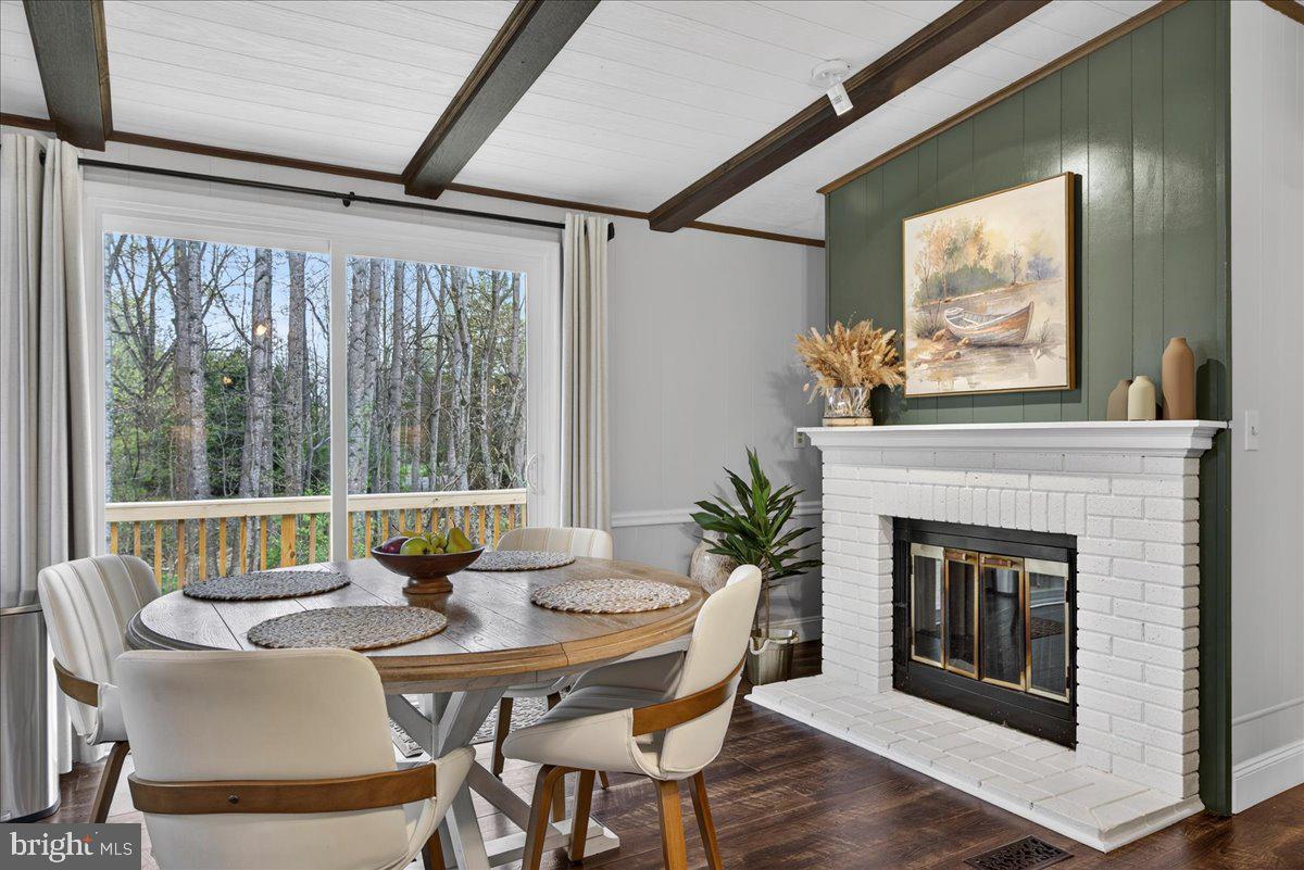 66 Ordinary Road Mineral, VA 23117 - Photo 17 of 96 a dining room with furniture wooden floor a fireplace and a chandelier