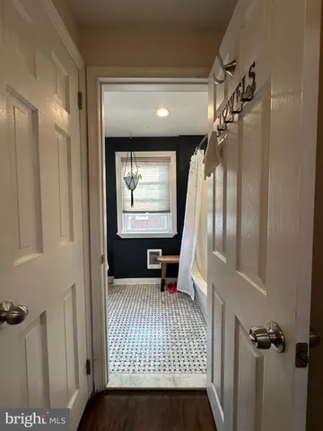 a view of a hallway with wooden floor and windows