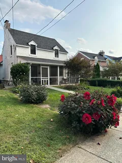 a front view of a house with a big yard and potted plants