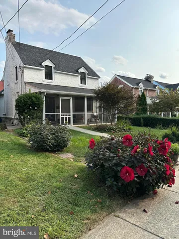 a front view of a house with a big yard and potted plants