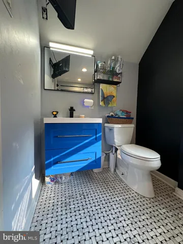 a bathroom with a toilet a sink and mirror