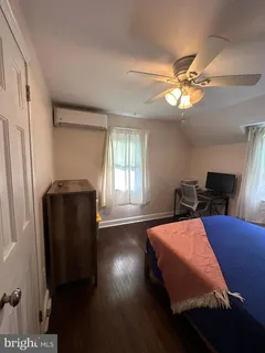 a bedroom with bed and wooden floor