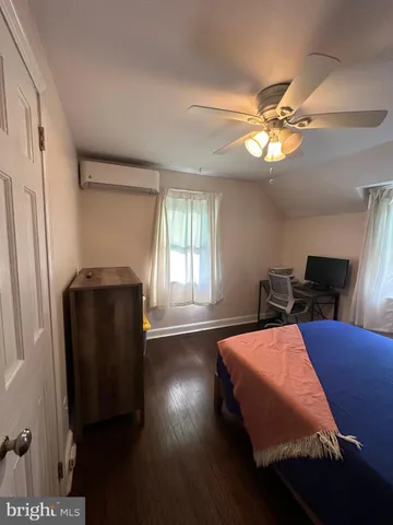 a bedroom with bed and wooden floor