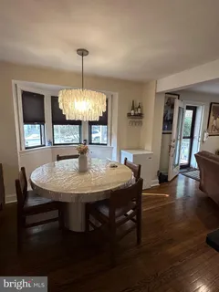a dining room with furniture window and wooden floor