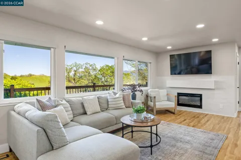 a living room with furniture fireplace and a large window