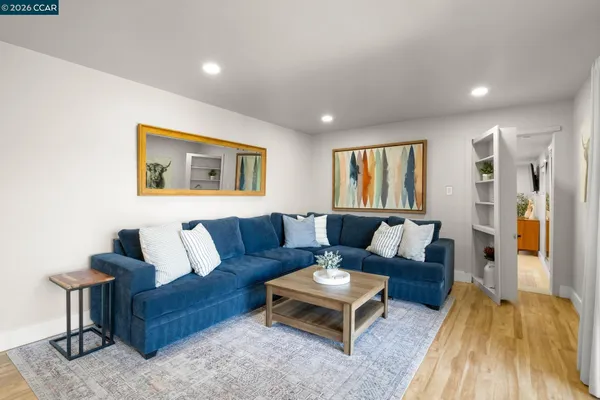 a living room with furniture and a wooden floor