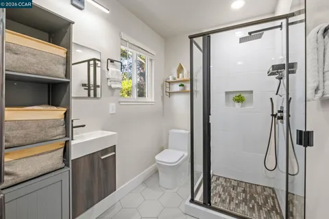 a bathroom with a granite countertop sink a toilet and shower